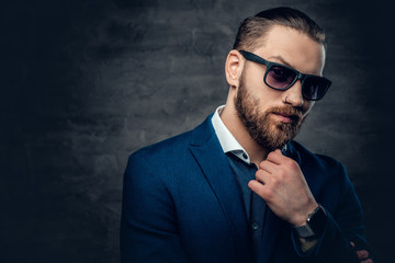 Fototapeta premium Stylish bearded male in sunglasses over dark grey background.
