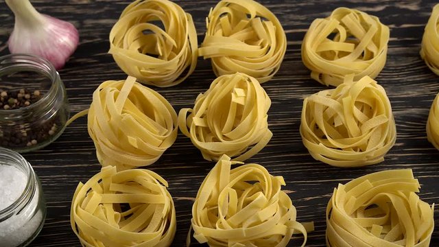 pasta, oil, tomatos and garlic on wooden background