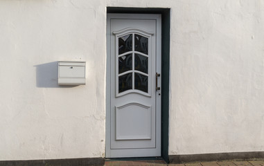Weiße Haustür und weiße Fassade