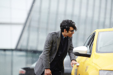 Businessman catching taxi on rainy day