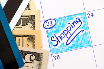 Reminder Shopping in calendar with dollar bills and credit cards