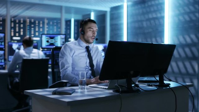 Camera Flies Actively Through System Control Center Showing Professional Security Personnel Working at Their Workstations With Multiple Displays.  Shot on RED EPIC-W 8K Helium Cinema Camera.
