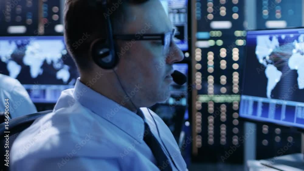 Poster Camera Flies Actively Through System Control Center Showing Professional Security Personnel Working at Their Workstations With Multiple Displays.  Shot on RED EPIC-W 8K Helium Cinema Camera.