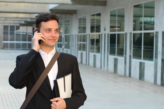 Focused Businessman Walking During Phone Call Outdoors