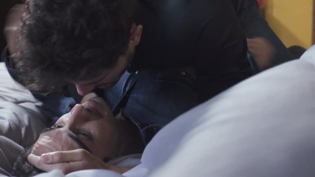 fight and Passionate kiss between a homosexual couple on the bed