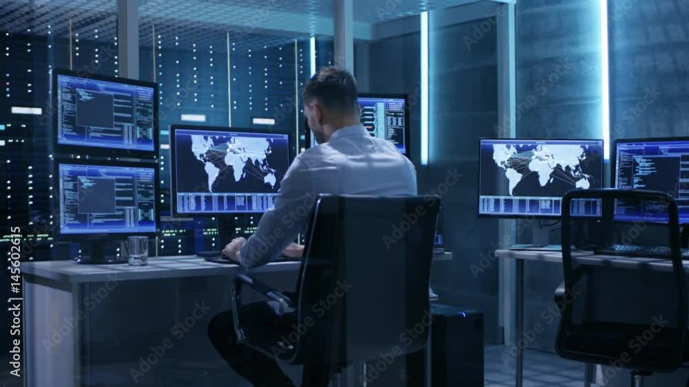 Aufkleber technical controller working at his workstation with multiple displays. he's alone in system control