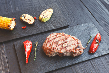 Grilled beef steak closeup on dark wooden table background