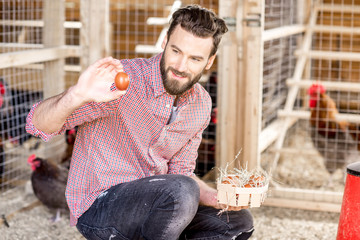 Farmer collecting eggs at the wooden henhouse with chickens © rh2010