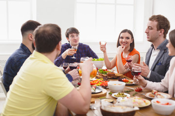 Group of happy people at festive table dinner party