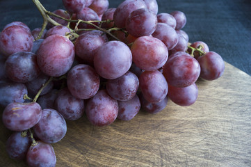 grapes on a wooden Board. on a black background