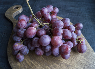 grapes on a wooden Board. on a black background