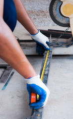 Worker hands use measuring tape measuring length of steel