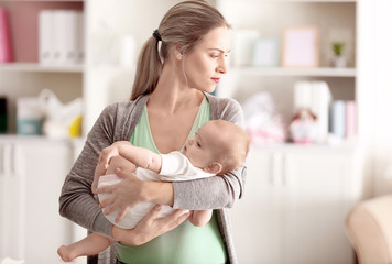 Depressed young woman with cute baby at home