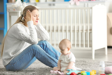 Depressed young woman with cute baby at home