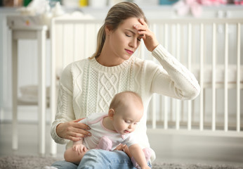 Depressed young woman with cute baby at home