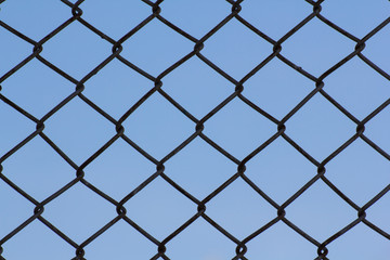 Fototapeta premium black wire fence and blue sky background