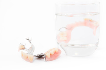 denture is cleaned in a glass of water. proper hygiene.