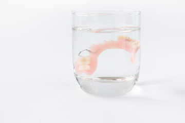 denture is cleaned in a glass of water. proper hygiene.