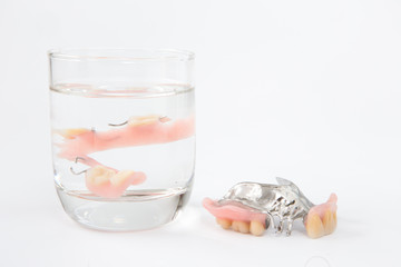 denture is cleaned in a glass of water. proper hygiene.