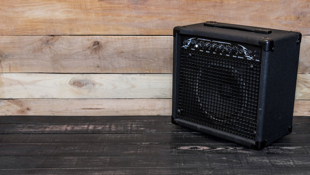 Electric guitar amplifier on wooden background