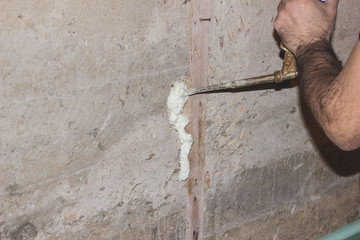 Builder foam fills the cracks in the concrete wall