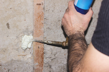 Builder foam fills the cracks in the concrete wall