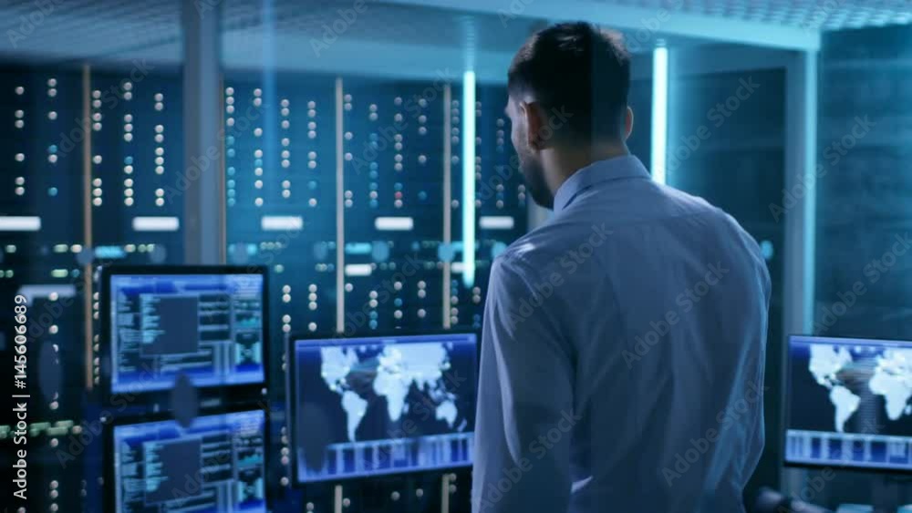 Aufkleber system security specialist working at system control center. room is full of screens displaying vari