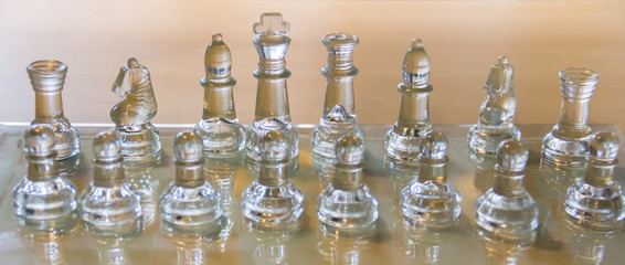 transparent chess set on wooden table