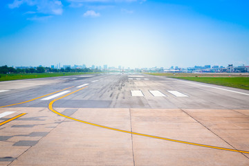 Runway of the Bangkok, Thailand international airport, airstrip in the airport terminal with marking on blue sky with sunlight background.