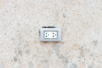 Wall socket on cement wall.