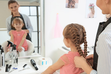 Cute little girl in hairdressing salon