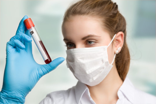 medizinische Mitarbeiterin mit Blutprobe im Labor