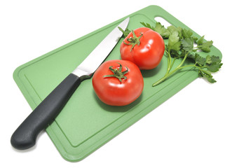 Помидоры и нож на разделочной доске 