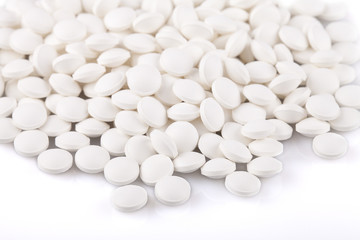 White vitamin D pills on a white surface. Vitamins isolated on white background.