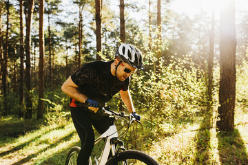 Handsome young European male wearing protective helmet and black sports clothing and glasses riding...