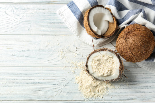 Half of nut with coconut flour on wooden background