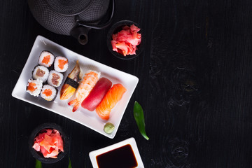Japanese sushi dish border close up on black wooden background with copy space
