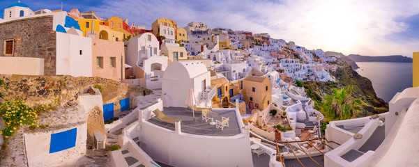 Oia town on Santorini island, Greece. Traditional and famous houses and churches with blue domes over the Caldera, Aegean sea - obrazy, fototapety, plakaty
