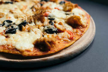 Homemade pizza with tomatoes, mozzarella and basil. Top view with copy space on dark stone table