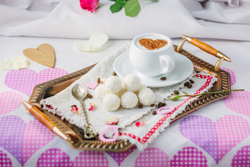 Breakfast in bed on copper tray over bed linens.