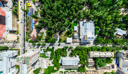 Aerial city view with crossroads and roads, houses, buildings, parks and parking lots, bridges. Helicopter drone shot. Wide Panoramic image.