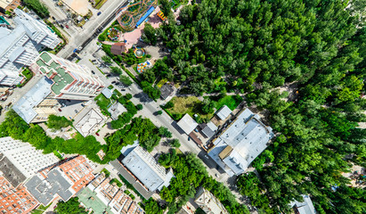 Aerial city view with crossroads and roads, houses, buildings, parks and parking lots, bridges. Helicopter drone shot. Wide Panoramic image.