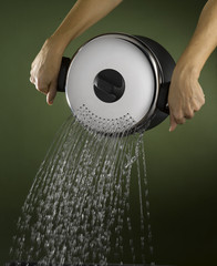 female hands pouring water out from a pot strainer lid 