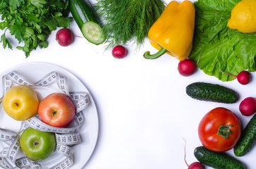 Apples with measuring tape and fresh vegetables isolated on white.