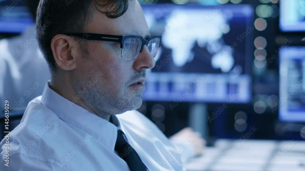 Poster In the System Control Center Team of Technicians Monitor System Stability. Close-up Faces Footage. Possible Air Traffic/ Power Plant/ Security Room Theme. Shot on RED EPIC-W 8K Helium Cinema Camera.