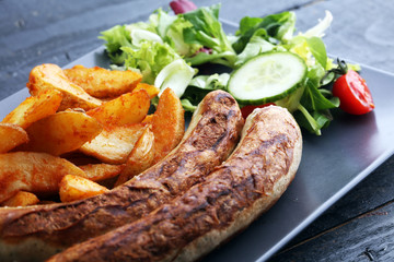 grilled sausages and potatoes and salad