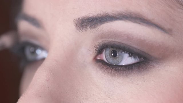 Applying  brown eye shadow On beautiful woman's Eyes