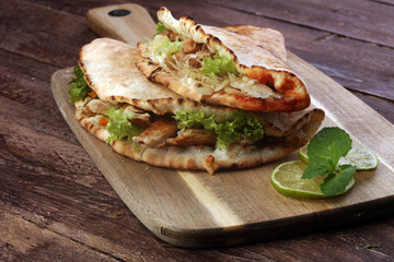 Delicious kebab sandwiches on wooden table