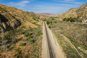 Straight long California desert railroad through a vally in the mountains.