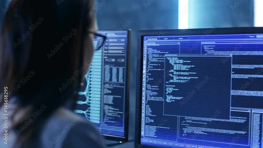 Leinwandbilder over the shoulder footage of female it engineer working in monitoring room. she works with multiple 